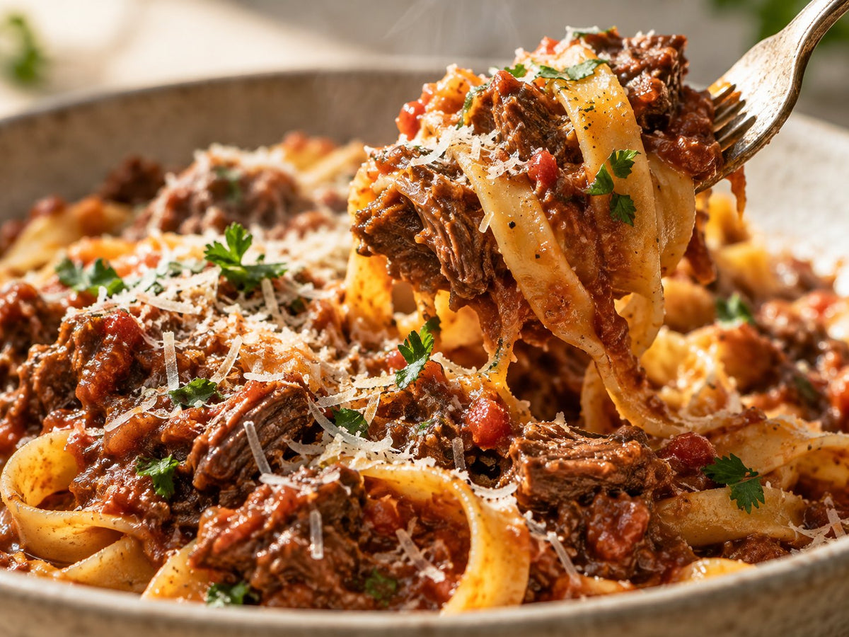 Fork-twirled pasta with glossy beef ragu — detail